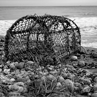 Buy canvas prints of Abandoned lobster pot on the beach in black and white by Chris Yaxley