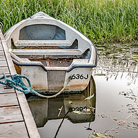 Buy canvas prints of Boat tied to wooden staging on the Norfolk Broads by Chris Yaxley