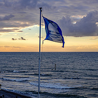 Buy canvas prints of Flag flying in the breeze over Sheringham beach  by Chris Yaxley