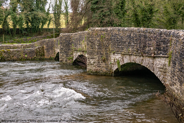 Sheepwash Bridge over a raging River Wye in Ashford in the Water, Derbyshire Picture Board by Chris Yaxley