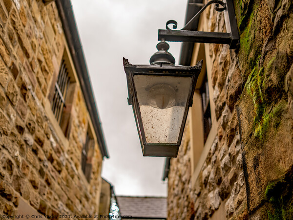 Victorian style light on an old and historic building in a narrow alley way Picture Board by Chris Yaxley