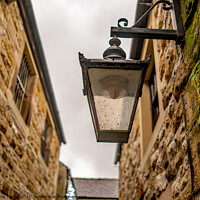 Buy canvas prints of Victorian style light on an old and historic building in a narrow alley way by Chris Yaxley