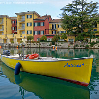 Buy canvas prints of  A small boat moored in the harbour of Sirmione, Lake Garda, Italy by Navin Mistry
