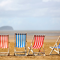 Buy canvas prints of Colourful wooden deck chairs on a beach by Steve Hyde