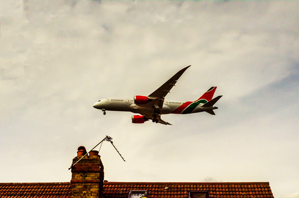 Passenger plane flying over the roofs of residenti Picture Board by Q77 photo