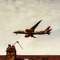Buy canvas prints of Passenger plane flying over the roofs of residenti by Q77 photo