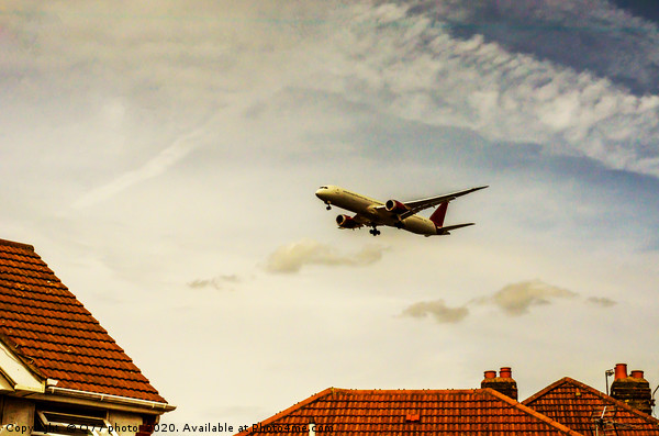 Passenger plane flying over the roofs of residenti Picture Board by Q77 photo