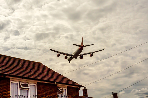 Passenger plane flying over the roofs of residenti Picture Board by Q77 photo