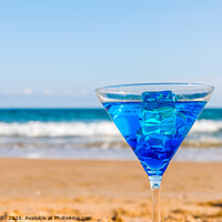 Buy canvas prints of drink in a martini glass on the background of the waves affecting the sandy beach, relax on the beach, refreshing drink during the holidays by Q77 photo