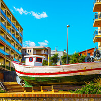 Buy canvas prints of view of the promenade in the seaside town, in the middle of the roundabout old fishing boat by Q77 photo