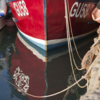 Buy canvas prints of Red fishing boat reflection by Amanda Hart