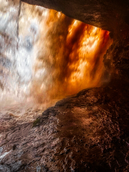 Standing behind A large waterfall in a cave Picture Board by simon cowan