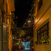 Buy canvas prints of a illuminated narrow alley with gardens and restaurants in the o by Stig Alenäs