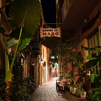 Buy canvas prints of Narrow alleyway with green plants at the night illuminated in th by Stig Alenäs