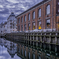 Buy canvas prints of buildings in Nyhavn are reflected in the water during the blue h by Stig Alenäs