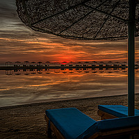 Buy canvas prints of two blue sunloungers and an umbrella standing on a by Stig Alenäs