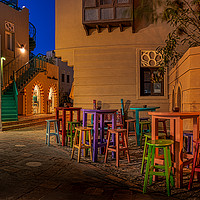 Buy canvas prints of coffee bar with colorful tables and chairs illumin by Stig Alenäs