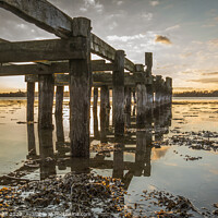 Buy canvas prints of Old wooden jetty with poles reflecting in the water by Stig Alenäs