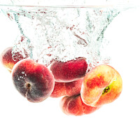 Buy canvas prints of Bunch of doughnut peaches isolated on white, splashing into water. by Przemek Iciak