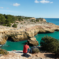 Buy canvas prints of Man looking at a wild hidden secret beach with amazing turquoise water in Algarve, Portugal by Luis Pina