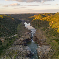 Buy canvas prints of Pulo do Lobo waterfall drone aerial view with river guadiana and beautiful green valley landscape at sunset in Mertola Alentejo, Portugal by Luis Pina