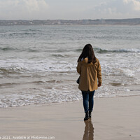 Buy canvas prints of Woman walking on a beach with a yellow jacket in Peniche, Portugal by Luis Pina