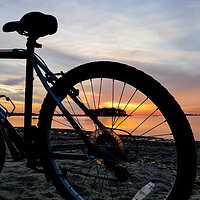 Buy canvas prints of Bike silhouette and sunrise light on beach by Miro V