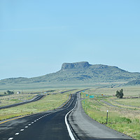 Buy canvas prints of Endless ribbon of blacktop heading towards a mesa  by William Jell