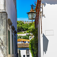 Buy canvas prints of Narrow White Street 11th Century Castle Wall  Obidos Portugal by William Perry