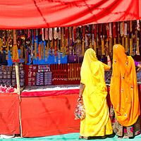 Buy canvas prints of Couple of unidentified women in traditional hindu wear saree buying or shopping jewelery items in the commercial street of Pushkar fair in state of Rajasthan, India. Colorful Indian culture concept by Arpan Bhatia