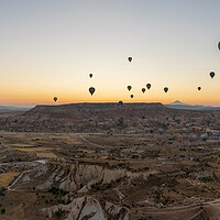 Buy canvas prints of Cappadocia, Turkey - September 14, 2021: Wide angle Panorama aerial shot of colorful hot air balloons together floating in the sky at early morning in Goreme against volcanic hills by Arpan Bhatia