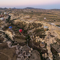 Buy canvas prints of Many colorful hot air balloons flight above mountains and rocky formation - panorama of Cappadocia at sunrise. Wide landscape of Goreme valley - billboard background for your travel concept in Turkey by Arpan Bhatia