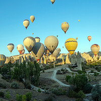 Buy canvas prints of Panorama of bunch of colorful hot air balloon flying early morning in Cappadocia, Turkey against typical rock formation due to volcanic activity in love valley located in Goreme national park by Arpan Bhatia