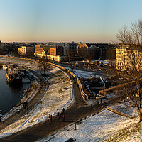 Buy canvas prints of Krakow, Poland - January 31, 2021: Panorama aerial drone shot of Cracow cityscape and polish architecture next to Vistula river during sunset in Winter with people doing leisure and walk in the evening. by Arpan Bhatia