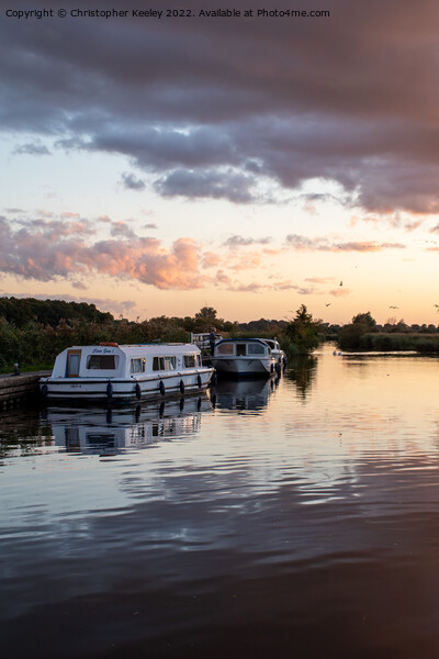Sunset over Norfolk Broads boats Picture Board by Christopher Keeley