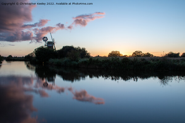 Sunset reflections at Turf Fen windpump Picture Board by Christopher Keeley