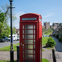 Buy canvas prints of Bamburgh Castle, village and red telephone box by Christopher Keeley