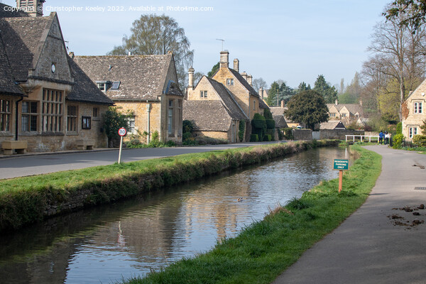 Sunny day at Lower Slaughter in the Cotswolds Picture Board by Christopher Keeley