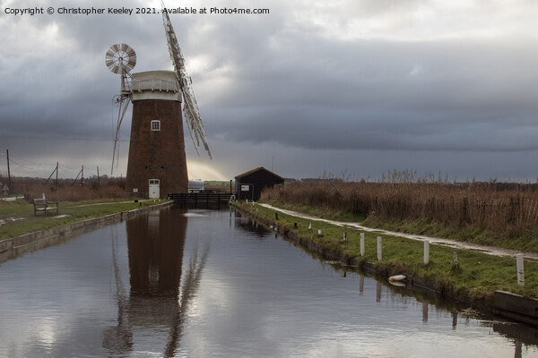 Cloudy skies over Horsey Mill Picture Board by Christopher Keeley