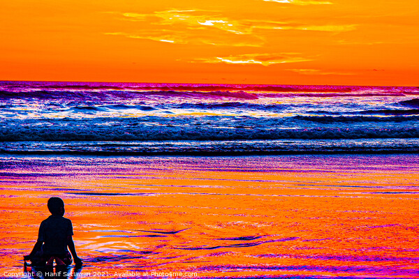 A young boy enjoys the sunset at a sand beach. Picture Board by Hanif Setiawan