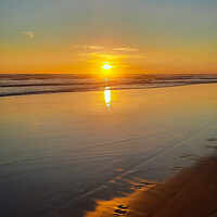 Buy canvas prints of Wide sand beach reflecting orange sunset sunlight. by Hanif Setiawan
