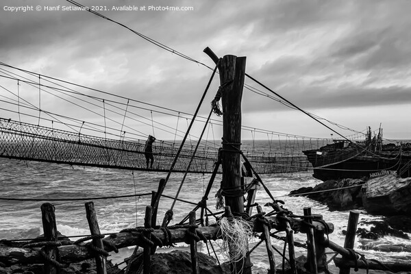 A man on a swinging rope foot bridge. Picture Board by Hanif Setiawan