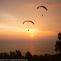 Buy canvas prints of Two paraglider over treetops and ocean at sunset by Hanif Setiawan