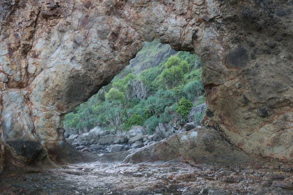 Frame view through a hole in a rock at a coast Picture Board by Hanif Setiawan