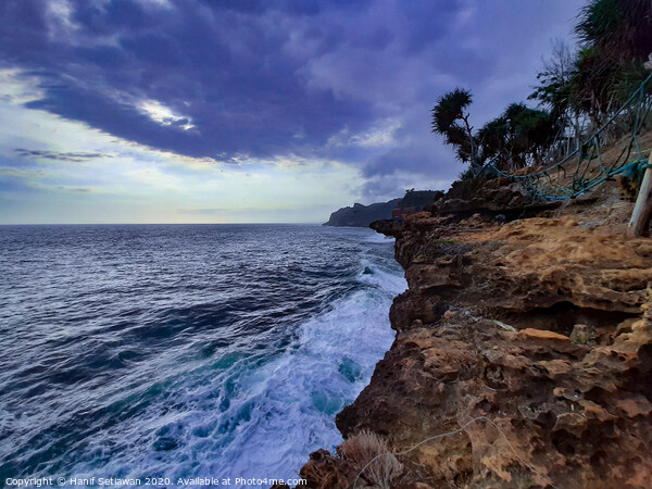 Big waves crashing against a steep rock Picture Board by Hanif Setiawan