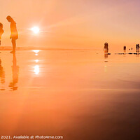 Buy canvas prints of Silhouetted people in a row on a wet sand beach. by Hanif Setiawan
