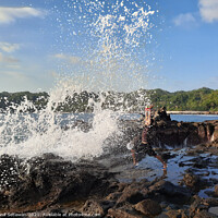 Buy canvas prints of A big wave hits a man on a rock plateau by Hanif Setiawan
