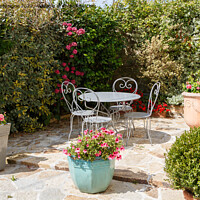 Buy canvas prints of Flowered terrace with garden furniture by aurélie le moigne