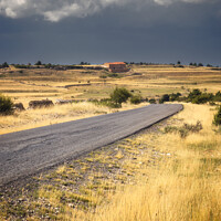 Buy canvas prints of Road Across a Countryside Scene Under Stormy clouds by Pere Sanz