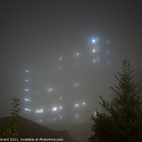 Buy canvas prints of Eerie sky scraper hospital lights shine through very thick fog. by Rhys Leonard